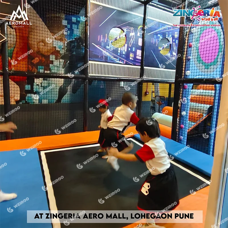 Kids jumping on safe indoor trampolines integrated into the soft play structure.