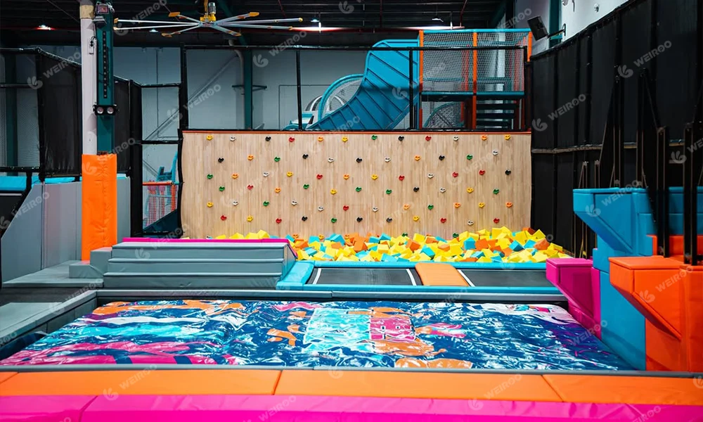Indoor rock climbing wall section with soft pastel color design in an Australian trampoline park.