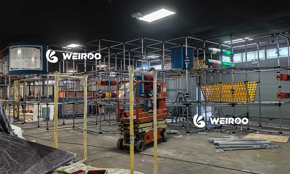 Professional trampoline park installation site showing galvanized steel structure assembly by Weiroo Play engineers.
