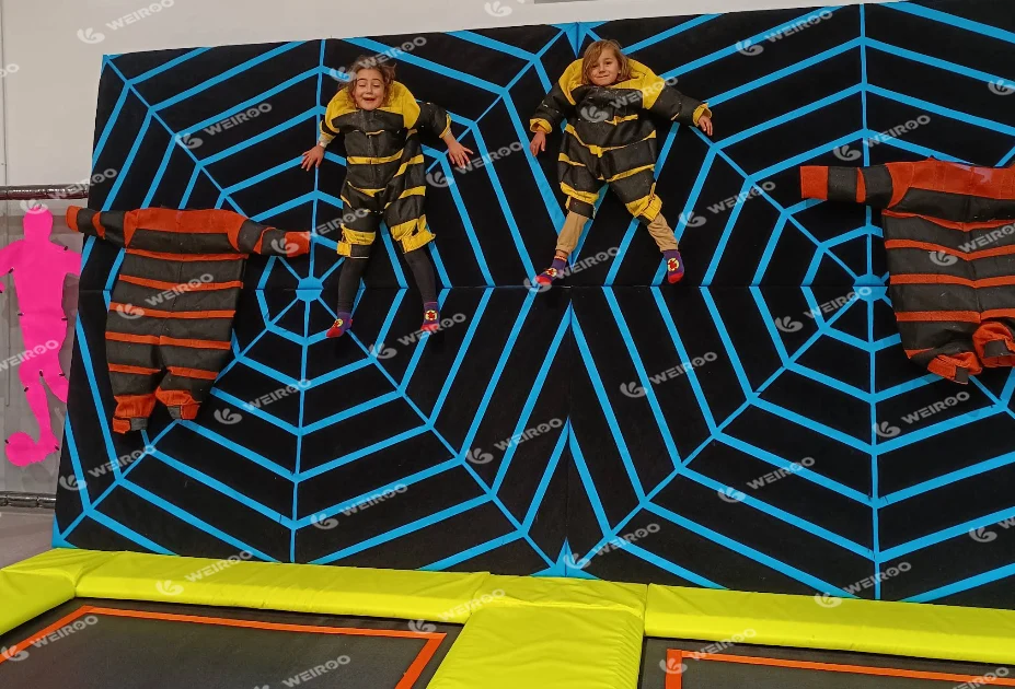 Kids sticking to the velcro spider wall jumping attraction.