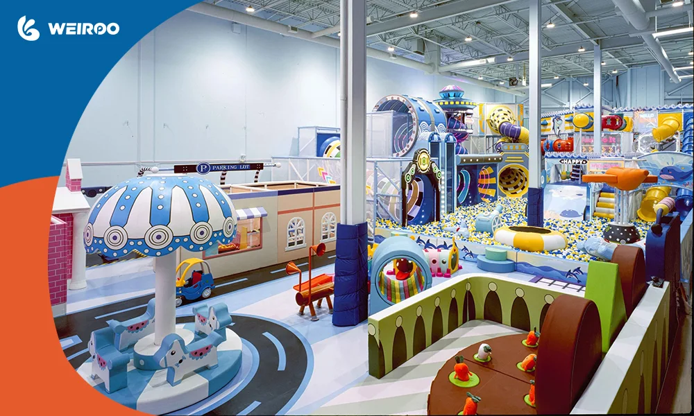A well-designed indoor playground layout showing a micro-city with traffic roads, a soft merry-go-round, and clear age zoning.