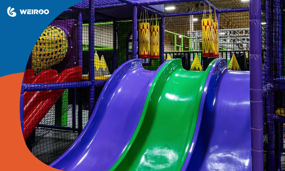 High-quality wavy slides and heavy-duty safety netting in a commercial play center, highlighting the safe indoor playground equipment needed to secure liability insurance.