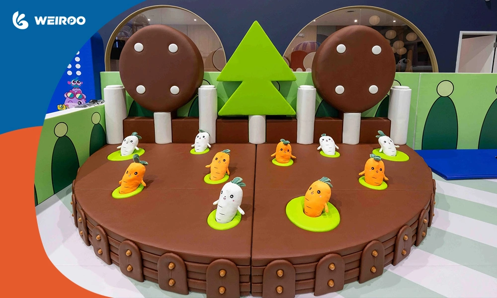 A safe, physically enclosed baby zone featuring a soft play carrot farm, perfect for indoor setups or mobile rental businesses.