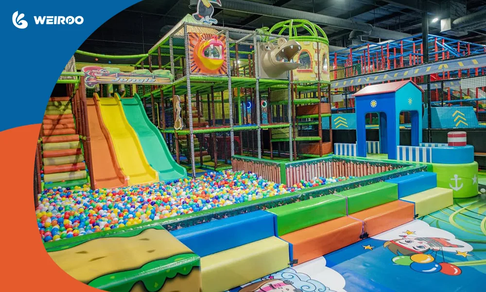 A colorful indoor soft play structure with multi-lane slides and a large ball pit, essential for attracting families with younger children.